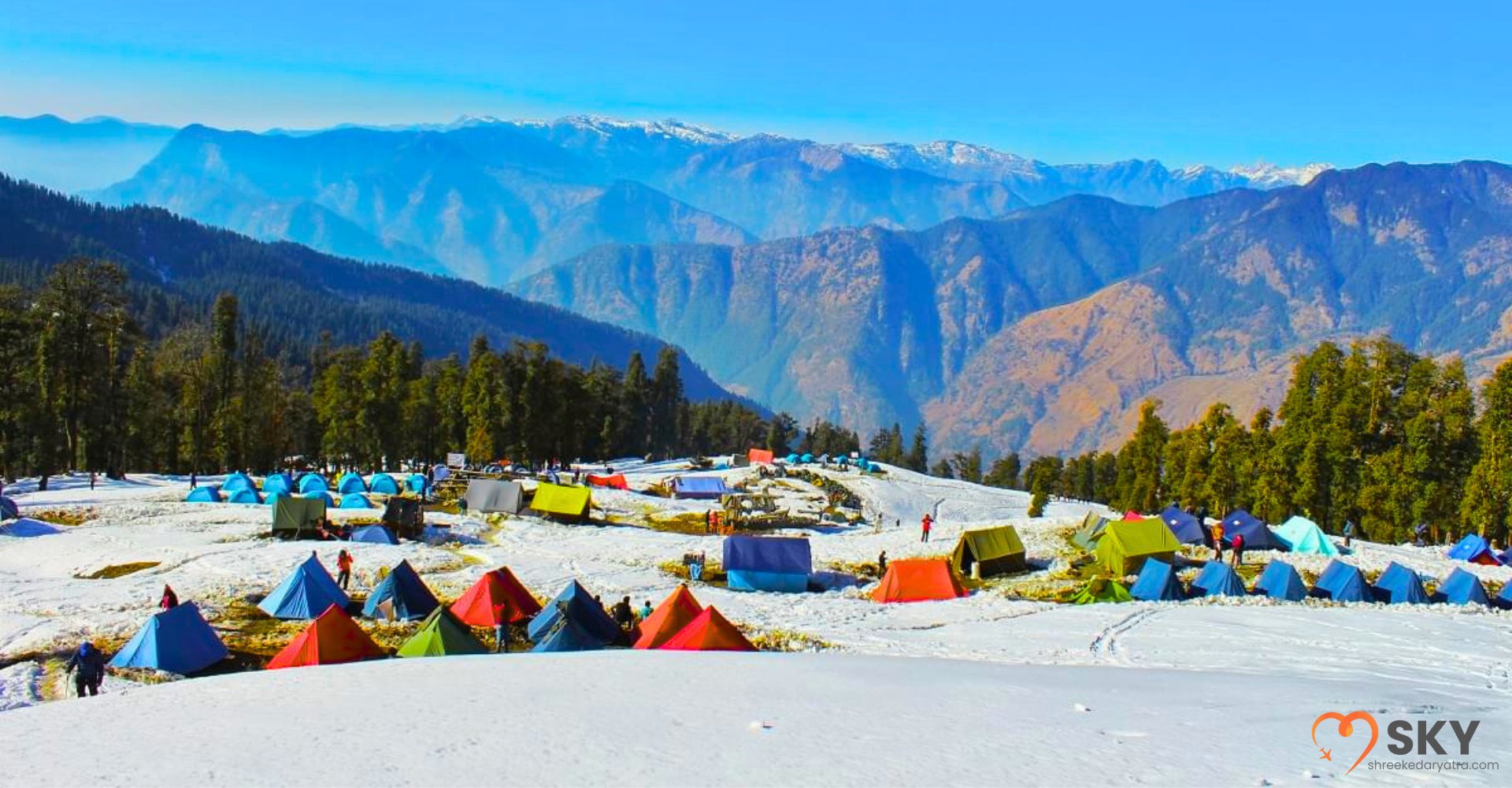 Scenic view of tents pitched at Kedarkantha base camp with rising sun over snowy ridges